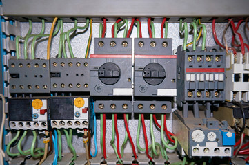 A group of electrical relays with connected wires.