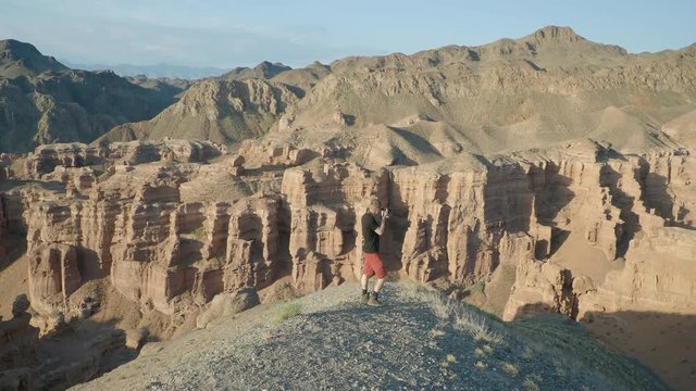Adventure photographer taking pictures in desert canyon kazakhstan
