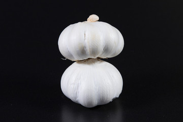 Zwei Knoblauchknollen vor schwarzem Hintergrund