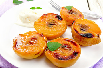 Quince baked with ice-cream in plate on lilac napkin