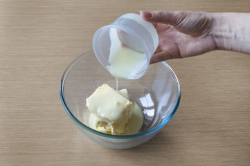 Adding ingredients condensed milk and butter in the bowl