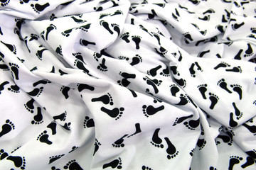 Black footsteps on white background of rippled abstract fabric graphic