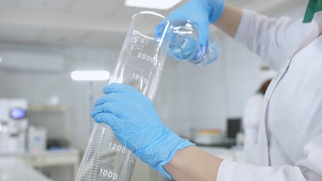 girl in a white robe holds a flask of reagents in her hands.the woman in the mask makes an experience.