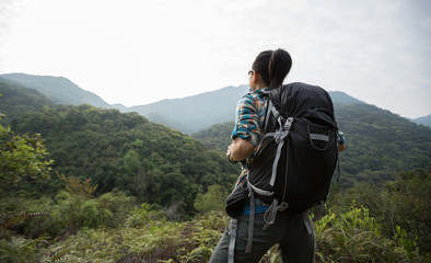 Fototapeta na wymiar woman backpacker enjoying the view on morning mountain valley