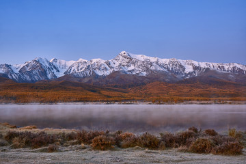 First snow on Lake. Colorful autumn landscape.