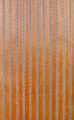 Chains curtain on a wooden background.