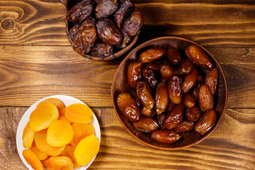 Dried apricots and dates fruit on wooden table. Top view