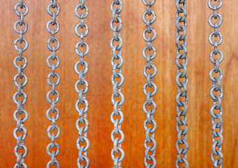 Chains curtain on a wooden background.
