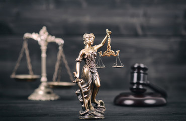  Lady Justice, Scales of Justice and Judge Gavel on a black wooden background.