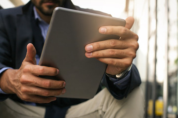 Businessman holding digital tablet. Focus on hands.