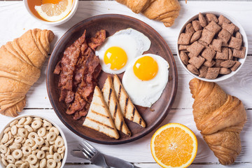 Breakfast with eggs , bacon and croissants