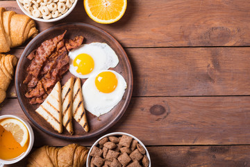 Breakfast with eggs , bacon and croissants