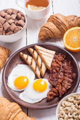 Breakfast with eggs , bacon and croissants