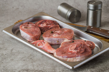 Raw turkey meat (steak) on a metal sheet for baking on a gray background. 