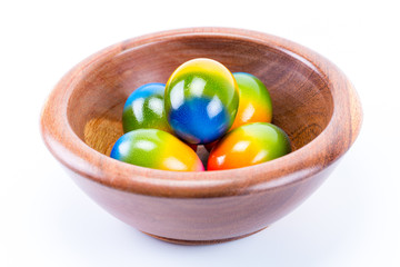 Easter eggs in a massaranduba bowl isolated in white background