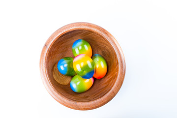 Easter eggs in a oak bowl isolated in white background top view