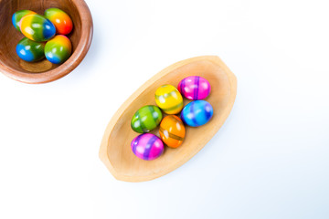 Easter eggs in two natural wood bowls isolated in white background