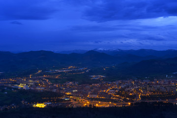Fototapeta na wymiar Lights at sunset in the city of Renteria with the mountains in the background, Basque Country
