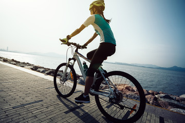 Fototapeta na wymiar female cyclist riding mountain bike on seaside