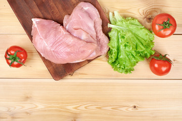 Fresh vegetables and dietary meat on wooden background. Healthy natural food on table with copy space. Cooking ingredients top view, mockup for recipe or menu