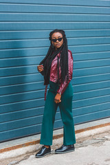 beautiful stylish young african american woman in sunglasses walking on street
