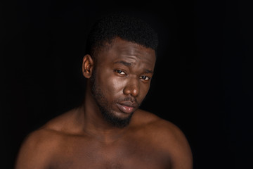 Fototapeta premium portrait of handsome young bare chested african american man looking at camera isolated on black