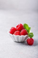 White ceramic bowl with fresh healthy berries. Raspberry. Copy space.