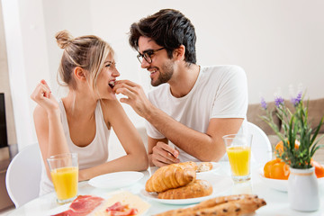 Obraz na płótnie Canvas Cute young couple enjoying their breakfast together