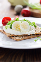 Chia seed crackers with cream cheese, cucumbers, tomato, quail egg and green onion