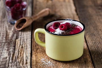 Smoothie mug with frozen raspberry,coconut flakes and flax seed