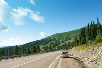 Sayany Mountains. The track. Summer sunny day. The car stopped on the roadside. Outdoors