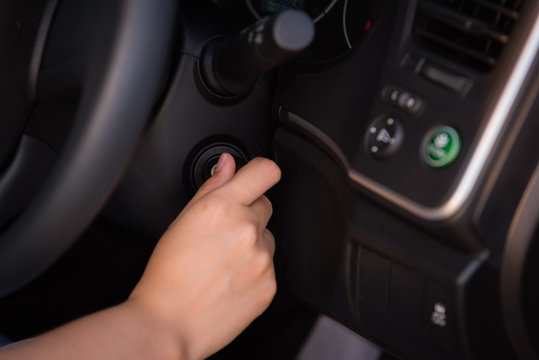 Close-up portrat of woman hand inserting key to turn on/off car engine
