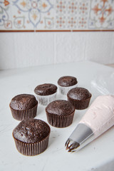 Tasty cupcakes on background table. Homemade chocolate muffin cupcake with cream buttercream icing. Birthday cupcake. Valentine cupcake sweets. Close up view delicious sweet dessert