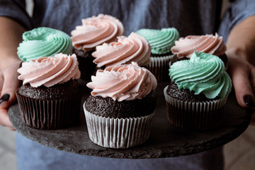 Tasty cupcakes on background table. Homemade chocolate muffin cupcake with cream buttercream icing. Birthday cupcake. Valentine cupcake sweets. Close up view delicious sweet dessert
