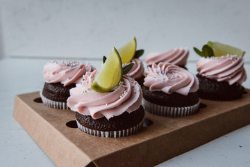 Tasty cupcakes on background table. Homemade chocolate muffin cupcake with cream buttercream icing. Birthday cupcake. Valentine cupcake sweets. Close up view delicious sweet dessert