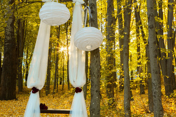 Wedding decorations in autumn forest. Beautiful wedding ceremony in autumn forest. Wedding Design elements.
