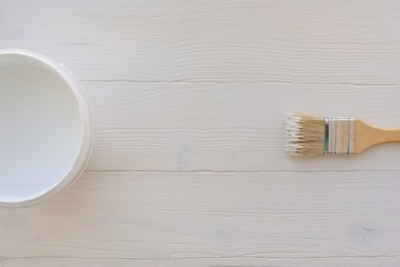 Paintbrush and can, paint brush and white color container on white wooden background , top view