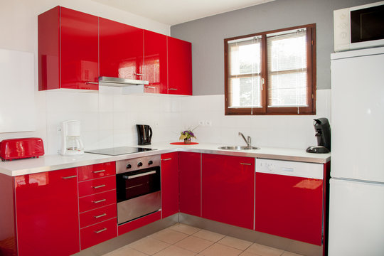 picture of a studio containing red small kitchen with a sink and microwave
