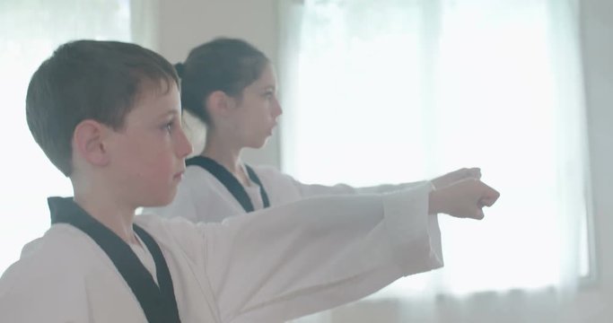 Slow motion footage of young kids practicing martial arts