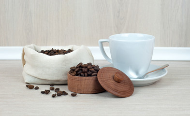 Cup of coffee, coffee beans on the table.
