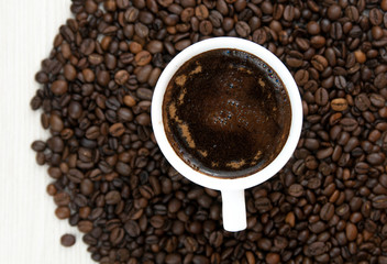 Cup of coffee on the coffee beans background.