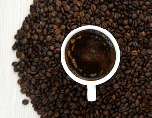 Cup of coffee on the coffee beans background.