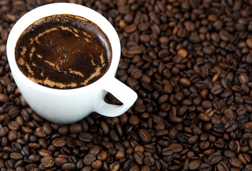 Fototapeta premium Cup of coffee on the coffee beans background.