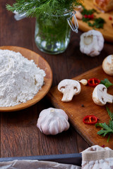 Vegetables on cutting board, plate with salt over white textured background, close-up, selective focus.