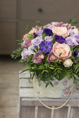 Коробка с цветами стоит на деревянном ящике