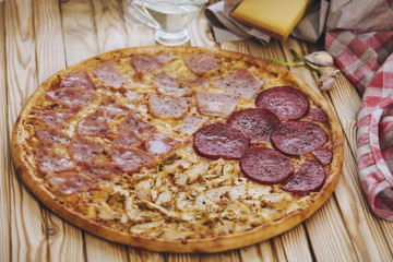 Italian pizza with four types of meat on a wooden table tasty and appetizing