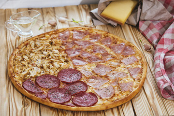 Italian pizza with four types of meat on a wooden table tasty and appetizing