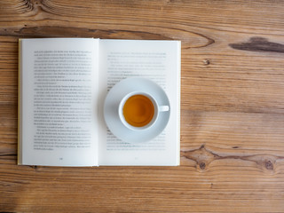 Weiße Tasse Tee auf einem Bücherstapel 