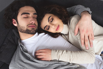 high angle view of young couple sleeping and hugging at home