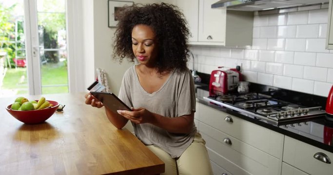 An attractive woman does her online shopping on her digital tablet